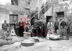 Dans la cour intérieure de l’orphelinat d’Alep : Nora Altounian assise sur un sac de céréales ; à sa droite, le pasteur Aharon Chiradjian, probablement en 1919 (coll. Bibliothèque Nubar).